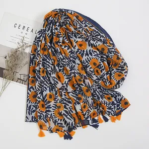 Detail of floral bohemian cotton linen scarf with vibrant orange flowers and fringe edges