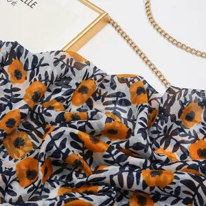 Detailed view of lightweight bohemian cotton linen scarf with orange floral pattern and gold decor