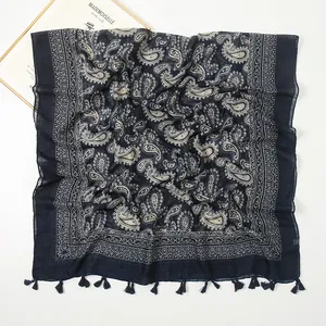 Detailed close-up of navy blue paisley cotton shawl with decorative tassel fringe edges
