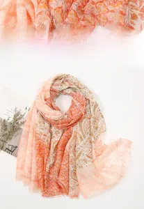 Detail of bohemian chiffon shawl featuring golden paisley leaves and fringed edges