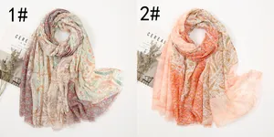 Detail of bohemian paisley scarves with golden threads and frayed edges in two colorways