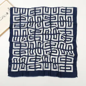 Nahaufnahme von Seidenschal mit geometrischem Quadratmuster und feinen Fransenrändern
