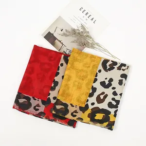 Detail of leopard print cotton linen scarves in red and yellow with frayed edges