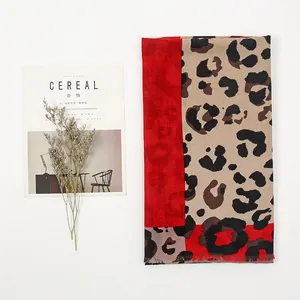 Flat lay of red and leopard print linen scarf with fringes on white background