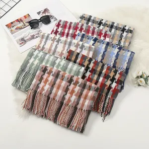 Close-up of thick winter scarves with mosaic check patterns and fringe tassels