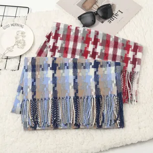 Detail of soft winter plaid scarf with tassels, featuring red and grey mosaic knit pattern
