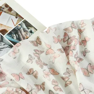 Dettaglio del tessuto leggero con motivi a farfalla rosa e eleganti dettagli di frange