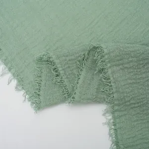 Pale green cotton linen crinkle scarf with raw frayed edges for a natural texture look