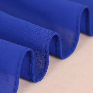 Nahaufnahme von dunkelblauem Chiffonstoff mit feiner Naht und weicher Faltenbildung