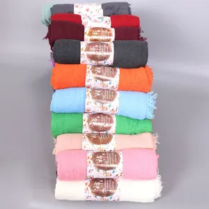 Detail of colorful cotton scarves rolls with floral paper labels showing texture and fabric