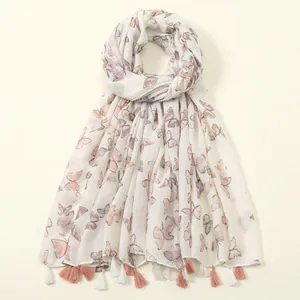 Dettaglio della sciarpa leggera con farfalle rosa ed eleganti nappe a frangia sulla base