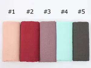 Detailed texture of five crinkled cotton linen scarves in various solid elegant colors