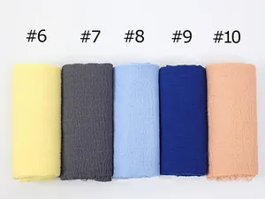 Detail of crinkled texture and frayed edges on cotton-linen hijabs in multiple colors