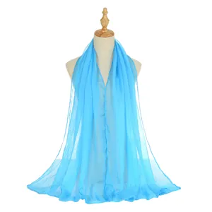 Lightweight bright blue chiffon shawl draped on a model for beach sun protection
