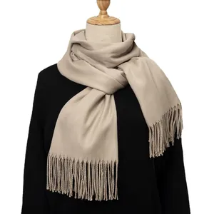 Beige cashmere-like thick winter scarf with fringes and twill weave texture on model
