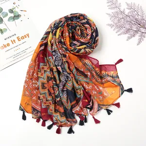 Écharpe bohème en lin avec motifs géométriques colorés et finitions à pompons