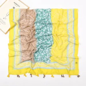 Detailed macro of soft voile scarf featuring paisley patterns and boho tassel fringe edges