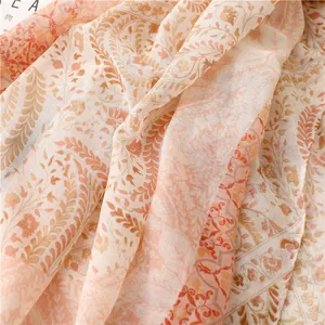Gros plan du motif paisley sur une écharpe en coton et lin orange avec des franges