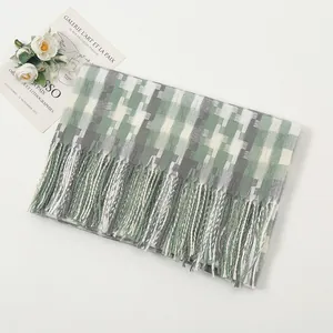 Detail of plaid scarf featuring green, grey, and white weave with fine fringe tassels