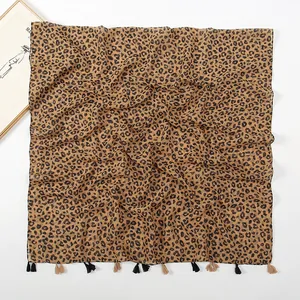 Detail of leopard print scarf featuring lightweight fabric and dual-color fringe tassels