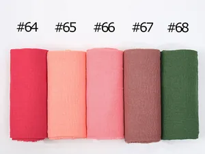 Detail shot of pleated cotton linen scarves in various shades with raw fringe edges