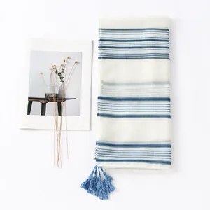 Blue and white striped cotton scarf with elegant tassels on a minimalist white background