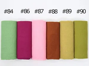Detail of crinkled cotton scarves showing textured fabric in assorted colors numbered 84 to 90