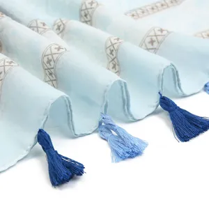 Close-up of soft voile shawl with vintage floral print and delicate blue fringe tassels