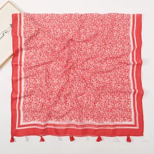 Close-up of red floral shawl with white flower print and delicate fringe details