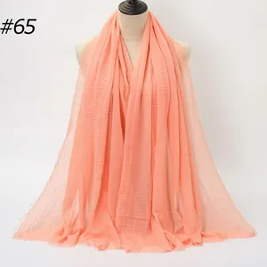 Solid peach cotton linen scarf with pleated texture and raw edges on mannequin