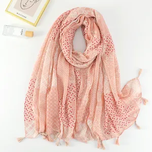 Detail of bohemian printed scarf with tassel edges and vintage floral patterns on pink linen