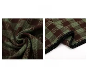 Detailed macro view of green and brown plaid scarf featuring soft fleece and neat edges