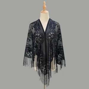Detailed close-up of dark blue hollow lace floral shawl with elegant tassel fringe