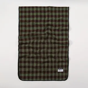 Green and brown plaid checkered winter scarf with premium knit texture and brand label