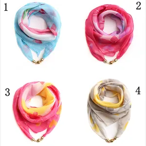Détail de foulards en mousseline imprimée avec boucles boules dorées élégantes
