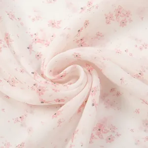 Close-up of soft cotton-linen fabric with pink floral patterns and elegant texture