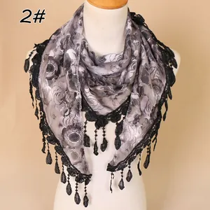Close-up of floral lace triangle scarf with gray rose pattern and tassel trim