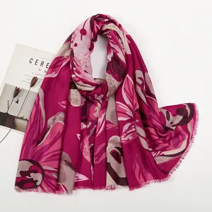 Détail d'une écharpe fleurie magenta avec bords à franges et tissu léger et très doux