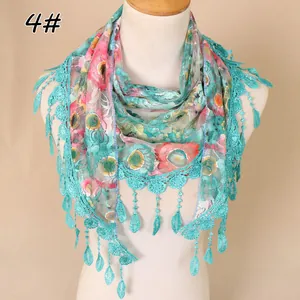Close-up of floral lace triangle scarf featuring green crochet lace and drop tassels