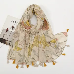 Detail of floral printed scarf with handmade tassels and linen-like fabric texture