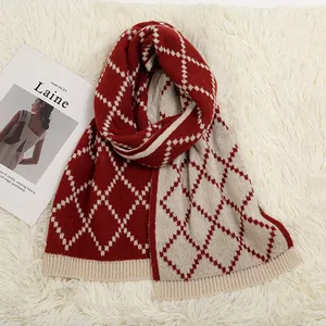 Thick knit winter scarf with burgundy and beige argyle pattern on white plush backdrop