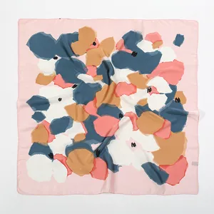 Detailed close-up of abstract floral print on a light pink square satin silk scarf