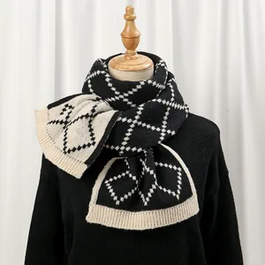 Detailed view of thick knit scarf texture with black and beige houndstooth check patterns