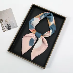 Close-up of artistic satin square scarf with abstract oil painting print on a tray