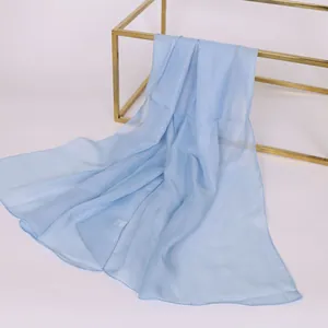 Elegante sciarpa in chiffon azzurro drappeggiata su una cornice in metallo dorato
