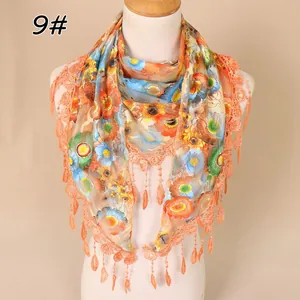 Detail of floral lace mesh scarf featuring vibrant orange fringe and delicate patterns