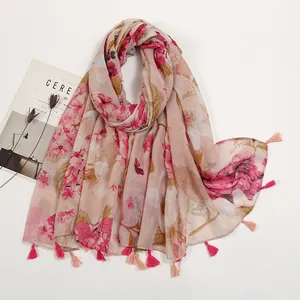 Detail view of pink floral cotton-linen scarf with red flower print and matching tassels