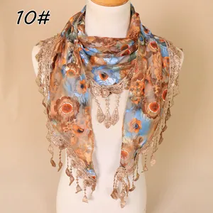 Detail of floral lace scarf featuring intricate gold crochet edges and dangling tassels