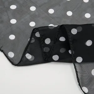 Sheer chiffon scarf featuring white polka dots on black fabric with reinforced edges