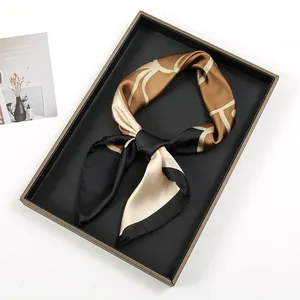 Detailed view of an oil painting graffiti print silk scarf knotted on a black tray